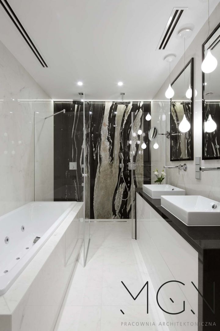 W łazience oświetlenie powinno być zróżnicowane tak samo jak w pokoju dziennym czy kuchni. W ciemnym na ogół pomieszczeniu brak naturalnego światła zrekompensują spoty, punkty halogenowe czy reflektorki, zainstalowane w regularnych odstępach w suficie. Fot. Pracownia Architektury Wnętrz MGN
