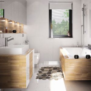 W łazience dominuje biel i drewno, co sprawia, że wnętrze jest przestronne i estetyczne. Fot. Domy w Stylu