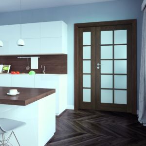 Klasyczne drewniane drzwi z kolekcji Cordoba i podłoga w jodełkę efektownie współgrają z drewnianymi blatami. Fot. Porta