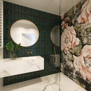 W drugiej łazience, gościnnej, na głównej ścianie położono płytki-kafelki Tonalite Krakle w kolorze mieniącej się różnymi odcieniami zieleni, a ściana pod prysznicem dostała dekoracyjną tapetę włoskiej marki Wall&Deco, w duże efektowne kwiaty. Fot. JMW Architekci