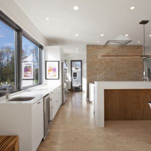 W białej, nowoczesnej kuchni również nie brakuje dużych przeszkleń. Fot. HAUS Architects
