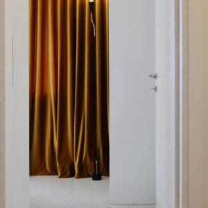 Prysznic został celowo oddzielony od reszty łazienki szklaną taflą oraz uzupełniony dwoma funkcjonalnymi wnękami. Fot. Giancarlo Allen