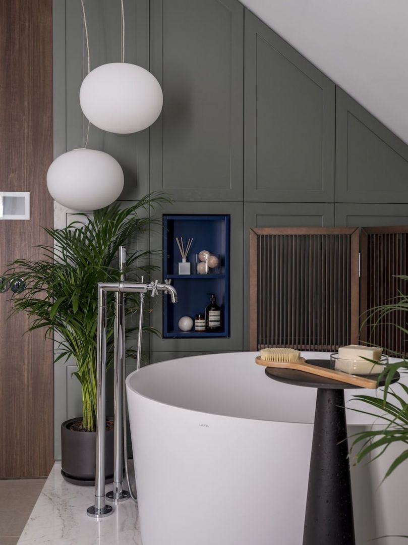 Delikatne zielone i niebieskie akcenty ożywiają całą łazienkę, które wyróżniają funkcjonalne schowki i akcesoria łazienkowe. Fot. Eugene Kulibaba