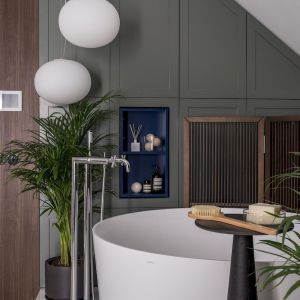 Delikatne zielone i niebieskie akcenty ożywiają całą łazienkę, które wyróżniają funkcjonalne schowki i akcesoria łazienkowe. Fot. Eugene Kulibaba