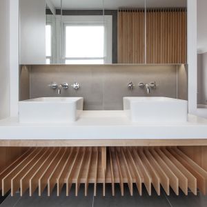 Jasną łazienkę ocieplają drewniane elementy. Fot. Nick Leith-Smith