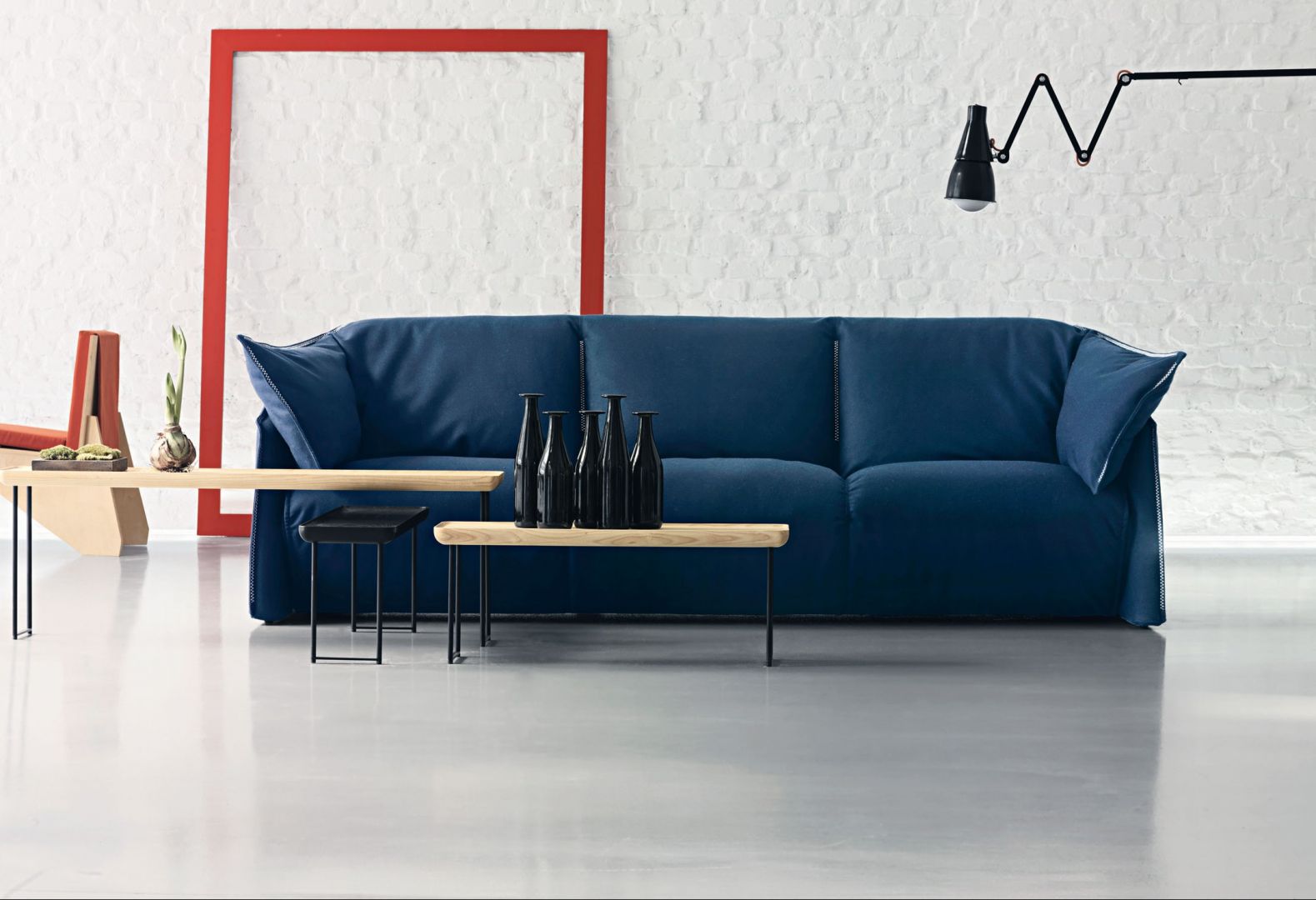 Sofa „La Mise” i stoliki kawowe „Torei”, wykonane z drewna i metalu. Forma stolików nawiązuje do tacy (nazwa ta „Torei” oznacza w języku japońskim tacę). Fot. Cassina
