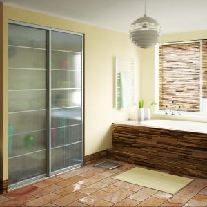 Szklane drzwi przesuwne to estetyczne i praktyczne  rozwiązanie również do wnętrz łazienkowych. Na zdjęciu system aluminiowy A100, profil Hudson anoda naturalna i szkło dekoracyjne. Fot. Indeco