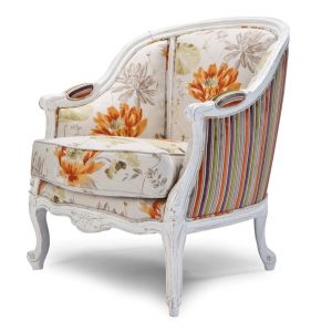 Urok fotelu "Ninfea" polega na zestawieniu wzoru pasów i kwiatów na tkaninie oraz klasycznej, "przecieranej", malowanej na biało konstrukcji. Producent: Exedra. Fot. Exedra. 
