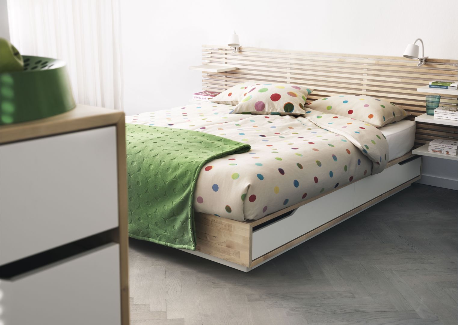 Łóżko z wysuwanym na bok pojemnikiem na pościel. Podstawa wykonana w formie klepki parkietu, z listewkowym szczytem łóżka Mandal, marki IKEA
Fot. IKEA