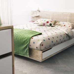 Łóżko z wysuwanym na bok pojemnikiem na pościel. Podstawa wykonana w formie klepki parkietu, z listewkowym szczytem łóżka Mandal, marki IKEA
Fot. IKEA