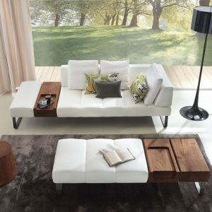 Sofa "Patmos" wraz ze stolikiem-pufem charakteryzujące się drewnianymi elementami. Producent: Riva 1920. Fot. Riva 1920. 