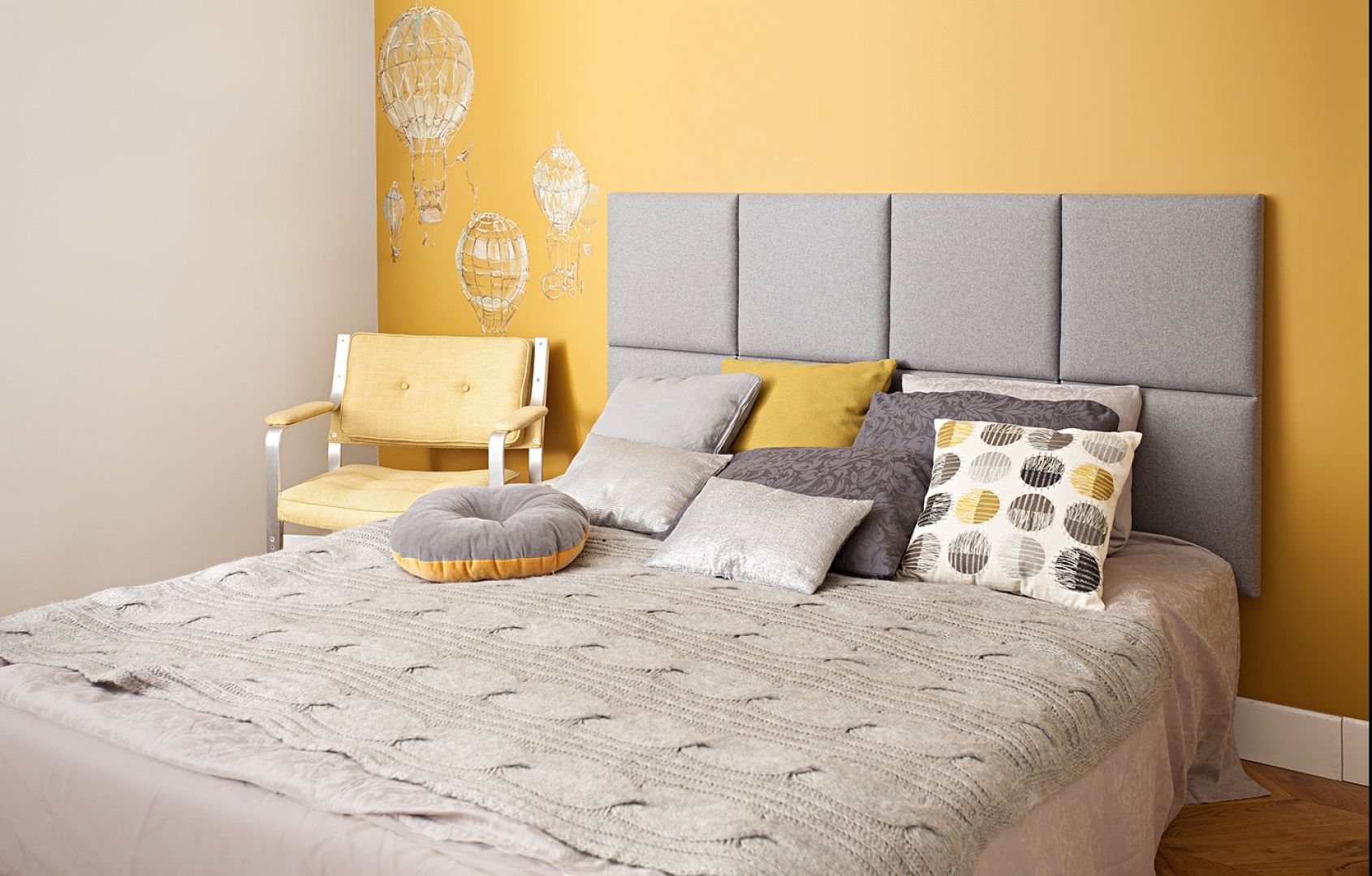 Szary zagłówek łóżka pięknie prezentuje się na tle ściany wykonczonej w kolorze żółtym. Fot. Made for bed