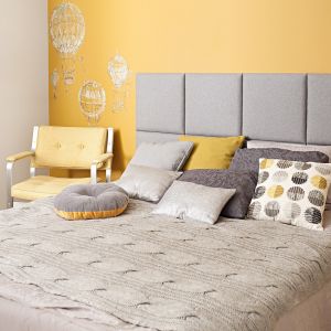 Białe łóżko z szarym zagłówkim pięknie wygląda na tle ściany wykonczonej w koorze żółtym. Fot. Made for bed