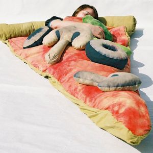 Śpiwór w kształcie pizzy, wykonany z ręcznie barwionej bawełny i wyłożony czerwonym atłasem. 
Fot. Theawesomer
