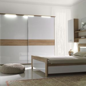 Sypialnia "Manhattan" marki Stolwit to połączenie białej, lakierowanej płyty oraz elementów imitujących drewno dębowe. Światło w sypialni wprowadza także oświetlenie LED. Fot. Stolwit 