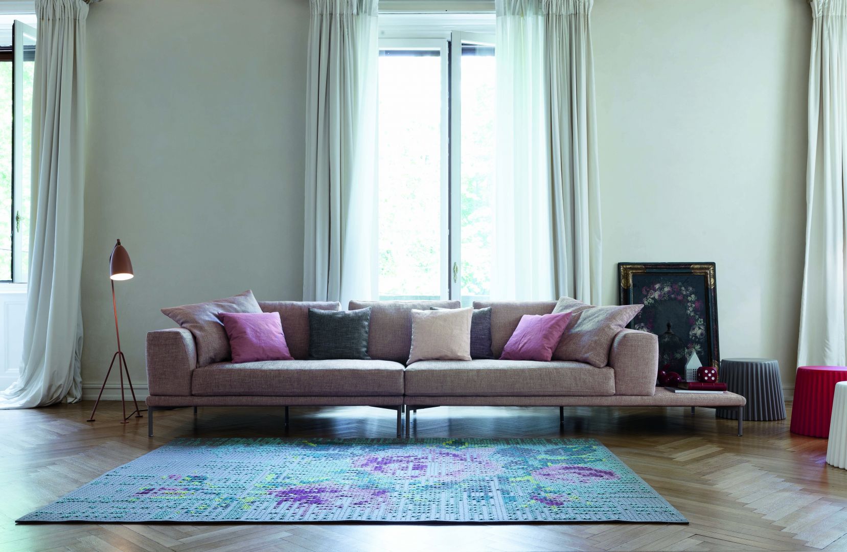 Cienki nóżki, proste siedzisko i dużo miękkich poduszek. Różowy, lekko przydymiony kolor idealnie pasuje do takiego modelu sofy. Fot. Bonaldo