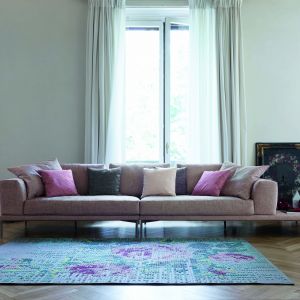 Cienki nóżki, proste siedzisko i dużo miękkich poduszek. Różowy, lekko przydymiony kolor idealnie pasuje do takiego modelu sofy. Fot. Bonaldo