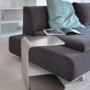 Półeczka dosuwana do sofy to ciekawa alternatywa dla klasycznego stolika. Dzięki prostej konstrukcji można ją ustawić niemalże w każdym miejscu. Fot. Square Space