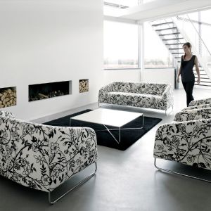 Pełna kolekcja sof i foteli z charakterystyczną czarno-białą tkaniną w kwiaty. Dobrze wygląda jako komplet, a ustawiona wraz z stolikiem na przeciw kominka tworzą ciepły zakątek w domu. Fot. Artek