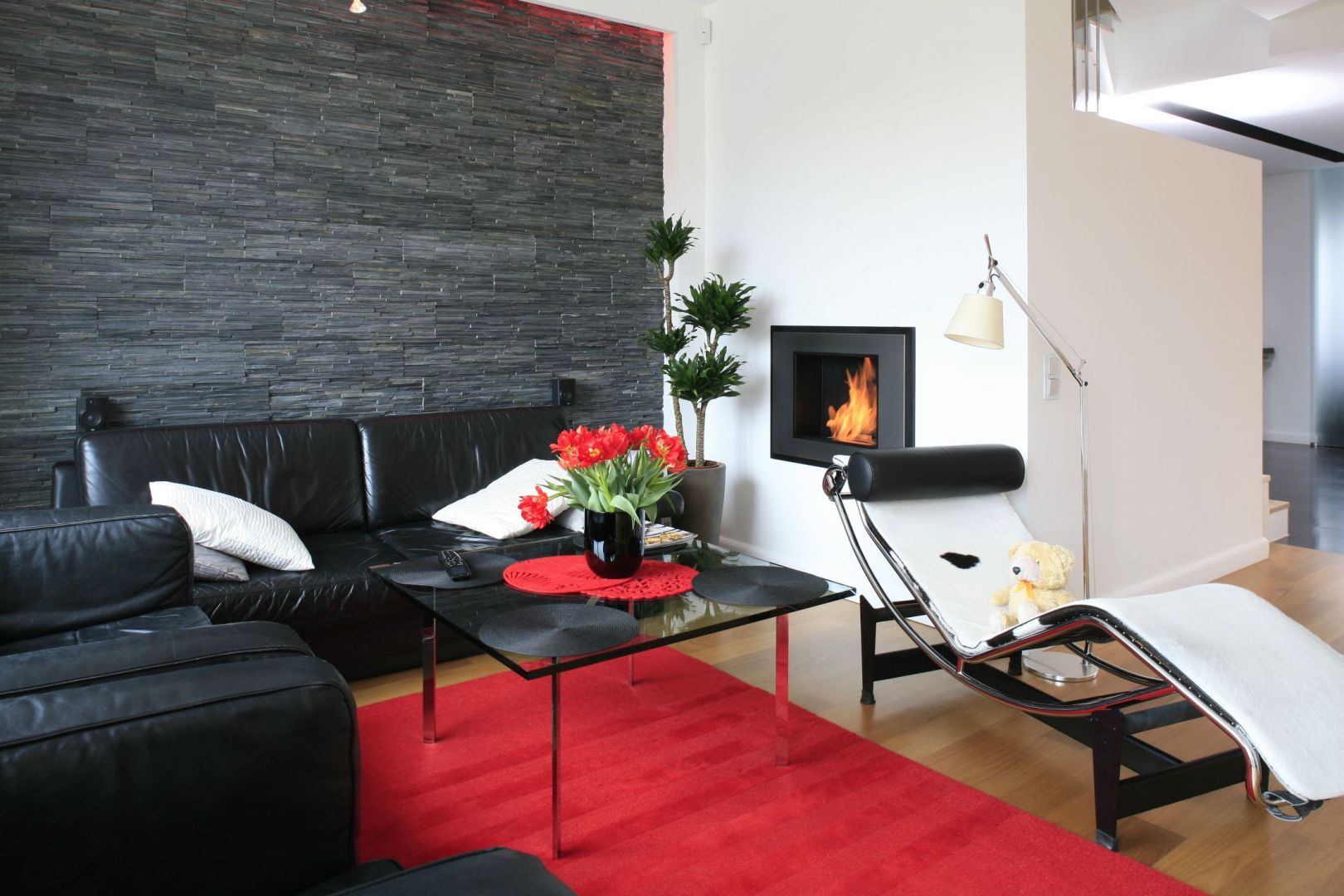 Skórzana sofa jest elegancka, dobrze prezentuje się w nowoczesnych stylizacjach z kominkiem. Projekt Michał Mikołajczak. Fot. Bartosz Jarosz