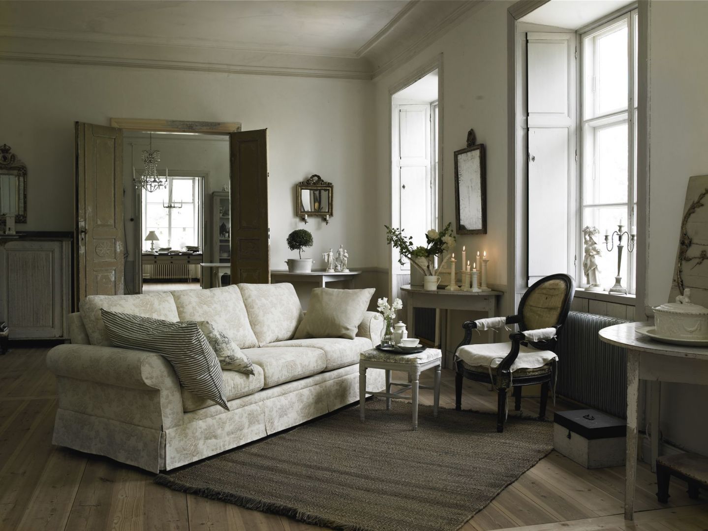 W stylowym salonie, wraz z stylizowanymi meblami świetnie komponuje się miękka sofa z poduchami. Fot. Skagen