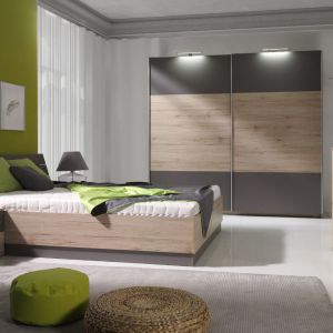 Sypialnia "Dione". Zestaw składa się z wygodnego łóżka z praktycznym pojemnikiem na pościel, z dużej, funkcjonalnej szafy z oświetleniem LED, komody oraz szafek nocnych. Fot. Maridex