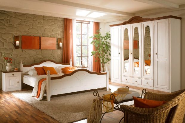 Biała sypialnia sosnowa z elementami z kolorze orzecha.