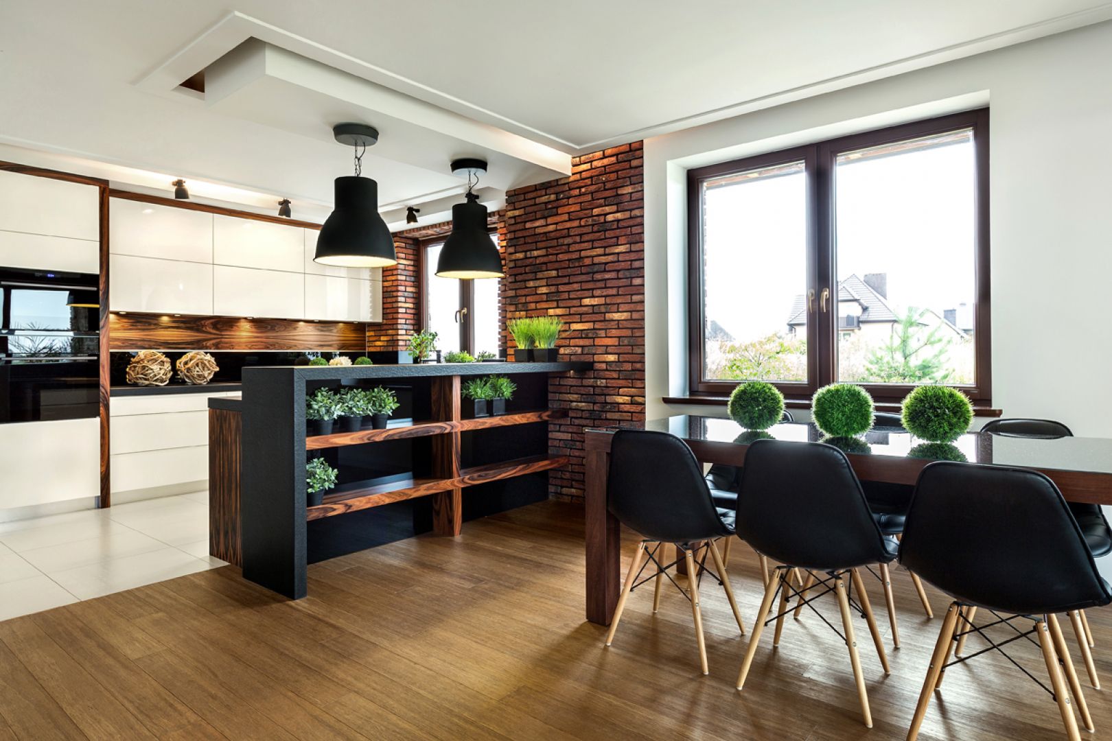 Otwarte na salon kuchnie z wysokim barem naturalnie dają przestrzeń do ustawienia przed nimi stołu z krzesłami. Fot. Pracownia VIGO/Max Kuchnie