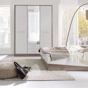 Sypialnia "Liverpool" (Stolwit) dostępna w najmodniejszym połączeniu drewna z kolorem białym w połysku. Ciekawym elementem kolekcji jest asymetryczna rama łóżka. Fot. Stolwit 