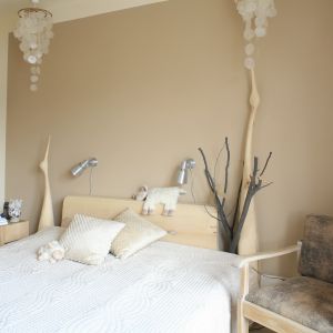 Sypialnia w bieli i beżu. Drewniane łoże wpisuję się w tą aranżację znakomicie. Projekt: Marta Kruk Fot. Bartosz Jarosz