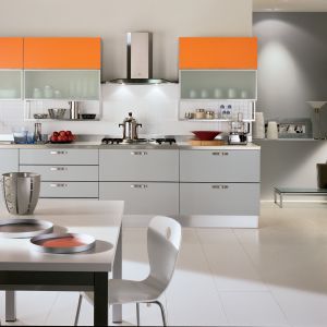 Modne połączenie szarości i koloru pomarańczowego. Otwarte półki świetnie organizują kuchenną przestrzeń. Kuchnia wygląda wówczas jak profesjonalne miejsce pracy. Fot. HTH 