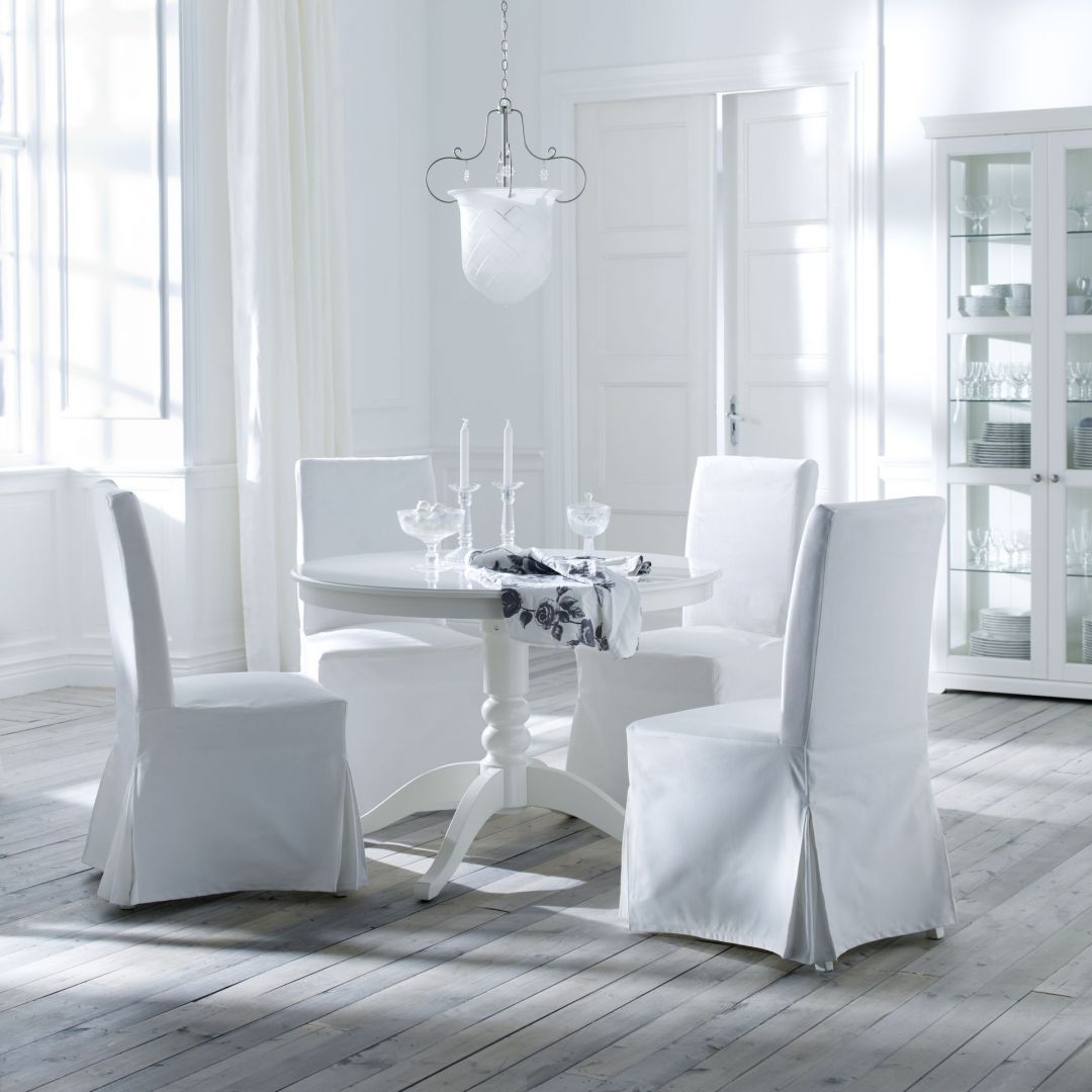 Biały okrągły stół i krzesła otulone materiałem do samej ziemi mogą kojarzyć się z restauracyjnym klimatem, jednak sprawdzą się doskonale, jeśli chcemy aby jadalnia w domu wyglądała elegancko. Fot. IKEA