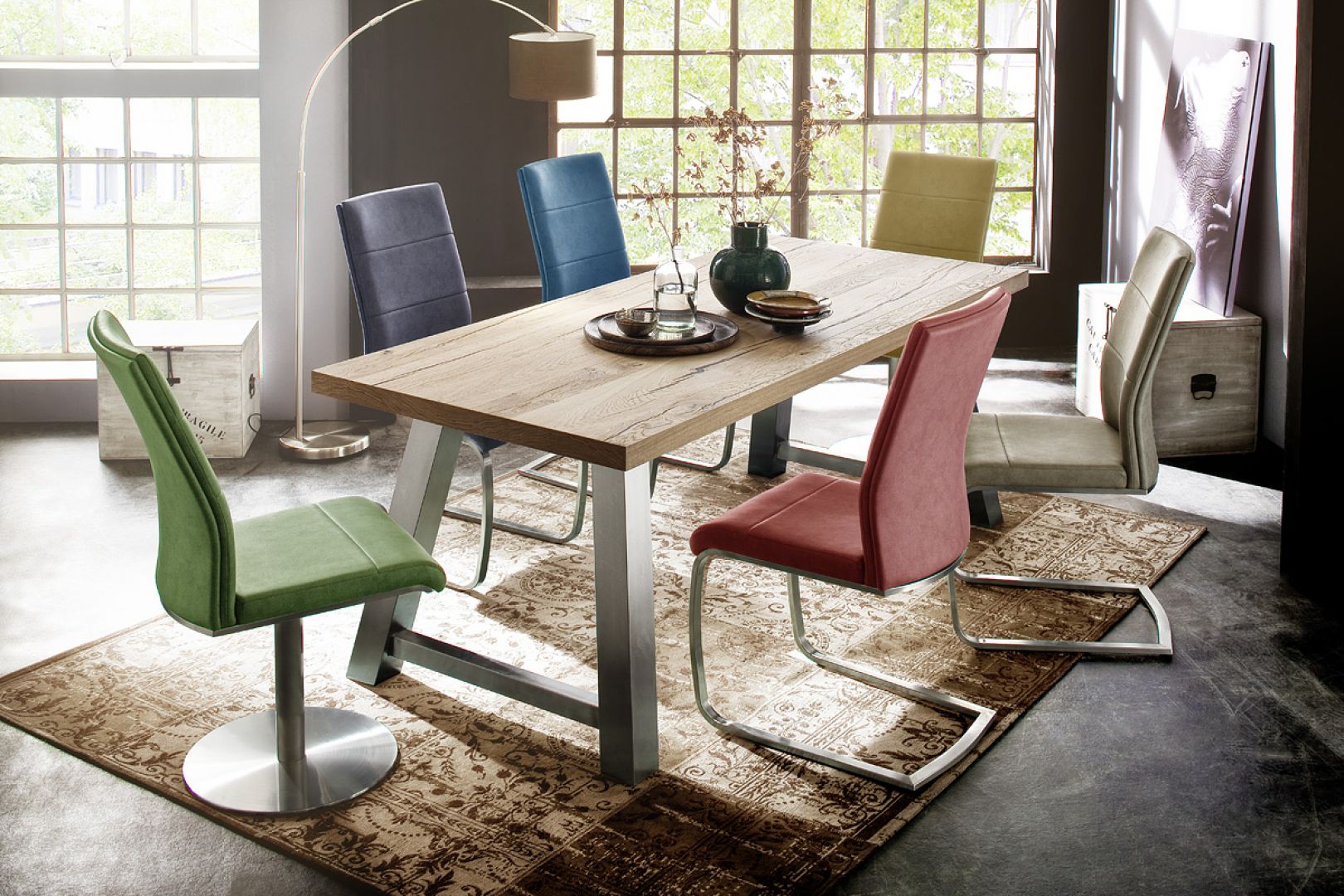 Drewniany stół Alvaro pięknie komponuje się z kolorowymi krzesłami. Całość prezentuje się bardzo stylowo. Fot. MC Akcent