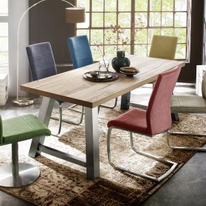 Drewniany stół Alvaro pięknie komponuje się z kolorowymi krzesłami. Całość prezentuje się bardzo stylowo. Fot. MC Akcent