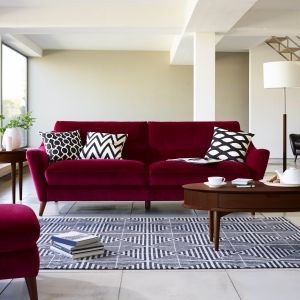 Modernistyczne wnętrza lubią ciemne, zdecydowane barwy. Dlatego sofa w kolorze słodkiego wina doskonale skomponuje się ze stolikiem w kolorze ciemnego orzecha. Dodatkowo stolik posiada ukryte pod blatem szufladki, które są świetnym schowkiem na czasopisma. Fot. Furniture Village