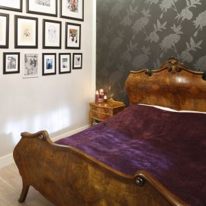 Masywne łóżko z oryginalną dekoracyjną ramą. Stolik nocy nawiązuje do niego stylistyką. Projekt: Monika Gorlikowska. Fot. Bartosz Jarosz 