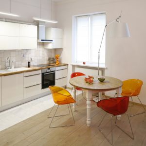 Okrągły stół świetnie sprawdzi się w małej jadalni, np. zlokalizowanej w kuchni. Plastikowe, kolorowe krzesła nadają jej nowoczesny wygląd. Projekt: Agnieszka Żyła Fot. Bartosz Jarosz 