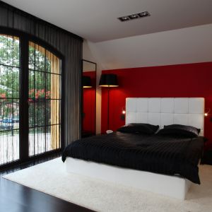 Biały zagłówek łóżka pięknie komponuje się z czerwoną ścianą. Projekt: Anna Kuk-Dutka. Fot. Tomasz Augustyn