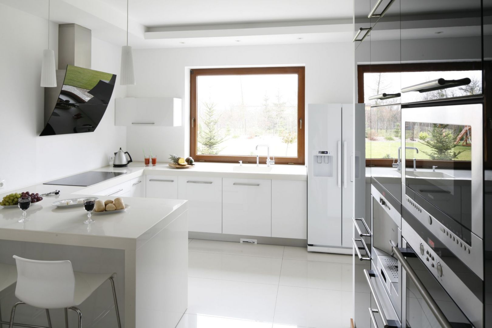 Popularnym rozwiązaniem, szczególnie  w kuchniach w domach jednorodzinnych, jest umieszczanie strefy zmywania pod oknem. Projekt: Piotr Stanisz. Fot. Bartosz Jarosz