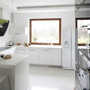 Popularnym rozwiązaniem, szczególnie  w kuchniach w domach jednorodzinnych, jest umieszczanie strefy zmywania pod oknem. Projekt: Piotr Stanisz. Fot. Bartosz Jarosz