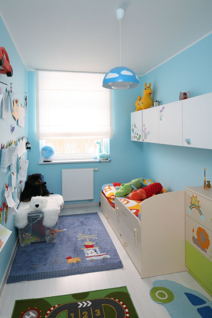 Niezbędne elementy, które powinny się znaleźć w pokoju dziecka to: biurko, szafka na ubrania, łóżko oraz miejsce na zabawki. W małym, wąskim pokoju nie jest to łatwe. Białe meble oraz funkcjonalnie zaplanowane schowki nie przytłoczą małego wnętrza. Projekt: Anna Maria Sokołowska. Fot. Bartosz Jarosz