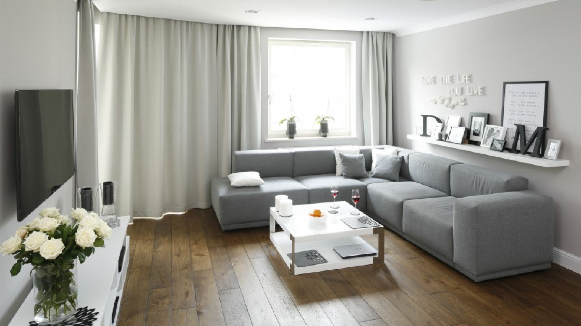 Szary kolor w salonie jest stylowy i szykowny, nie musi być tylko na ścianie, bardzo modne są szare sofy. Sofa do salonu może być duża, narożna, ale ciekawie wygląda także zestawienie dwóch mniejszych modeli. Projekt: Karolina Łuczyńska. Fot. Bartosz Jarosz