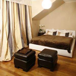 Idealny mariaż beżu oraz bieli. Miękkie, tapicerowane łóżko, zestawiono z brązowymi pufami, na zasadach kontrastu. Projekt: Joanna Liss. Fot. Bartosz Jarosz 