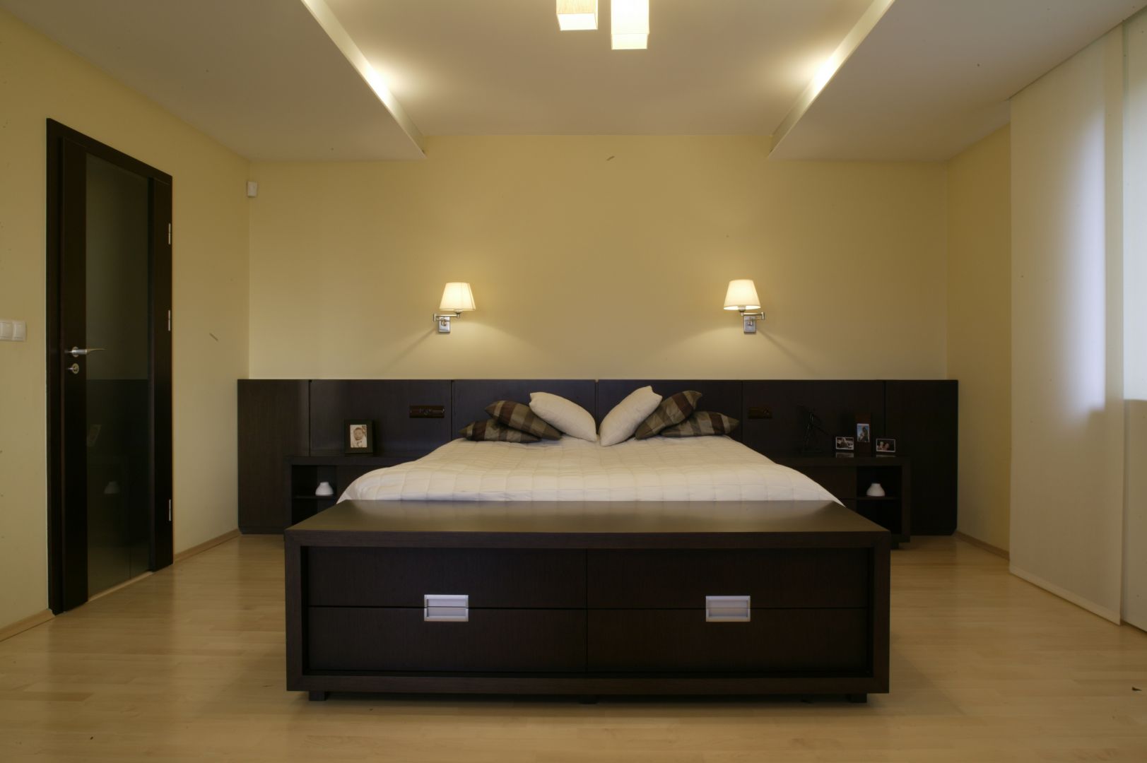 Sypialnia urządzona w minimalistycznym stylu. Masywne, drewniane łoże oraz ławka ulokowana tuż obok, to podstawowe elementy tego wnętrza. Projekt: Wojciech Mazur. Fot. Bartosz Jarosz