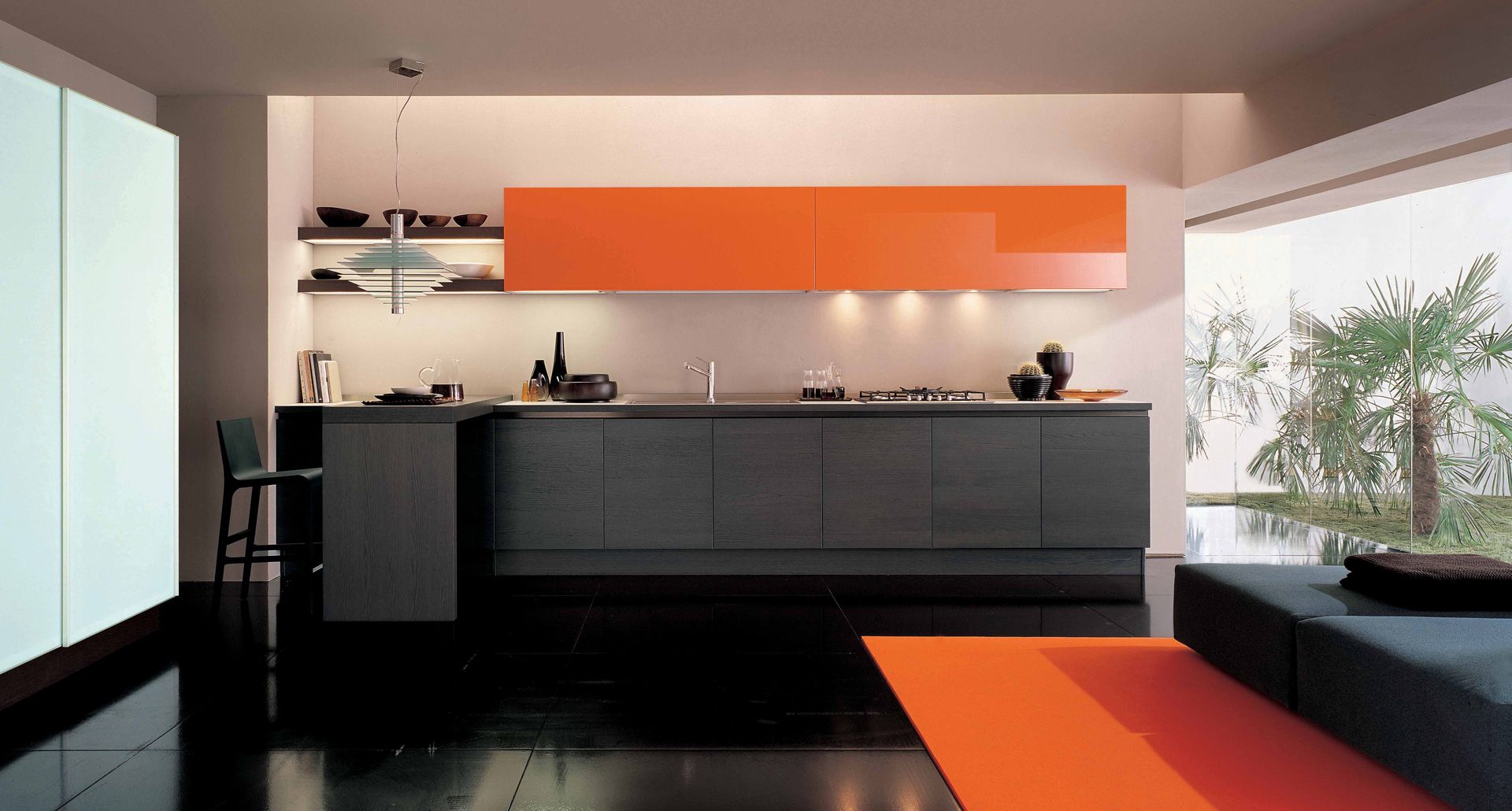 Odważne połączenie szarości z kolorem pomarańczowym w połysku. Kolorowa górna zabudowa ożywia wnętrze. Fot. Euromobil Kitchen