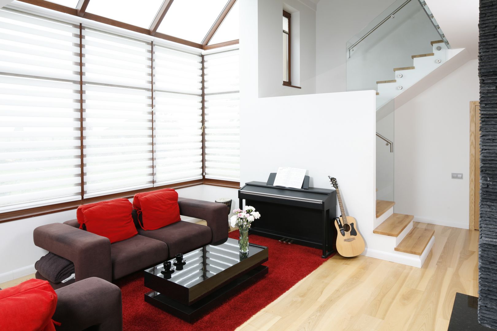 Jasny salon w domu jednorodzinnym. Mocnym akcentem wnętrza jest kolorowa sofa, która wyróżnia się geometryczną formą. Projekt: Michał Mikołajczak. Fot. Bartosz Jarosz  