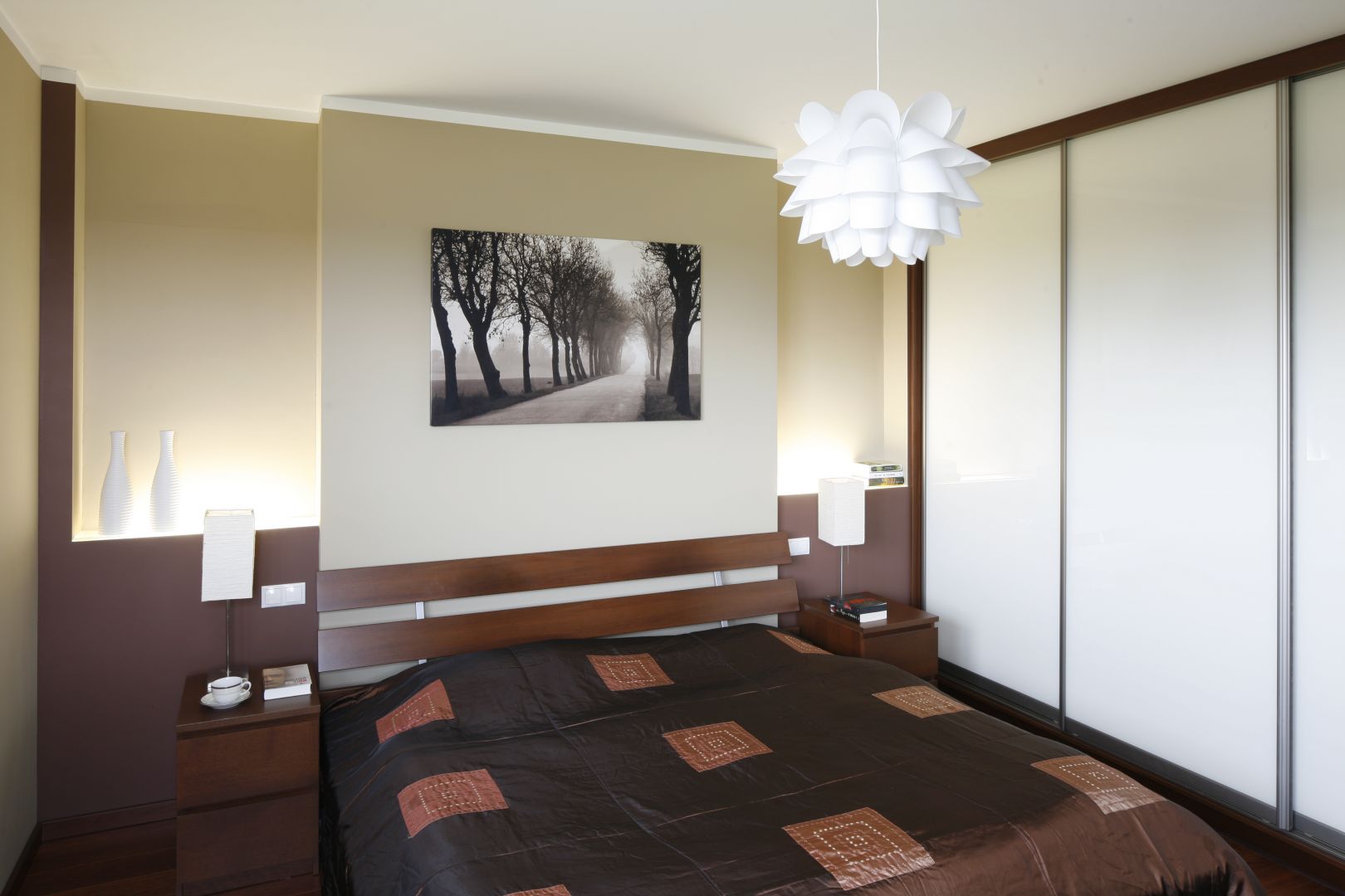 Przestrzenny obraz nad łóżkiem wizualnie powiększa wnętrze. Łóżko z dekoracyjnym, drewnianym zagłówkiem zapewnia komfort wypoczynku. Projekt: Piotr Stanisz. Fot. Bartosz Jarosz 