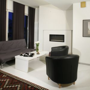 Salon urządzony w czerni i bieli to bardzo eleganckie rozwiązanie. Stylowe fotele świetnie uzupełniają aranżację. Projekt: Ovotz Design Lab. Fot. Bartosz Jarosz 