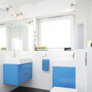 Jasna łazienka, pełna światła. Niebieskie meble pięknie urozmaicają wnętrze. Projekt: Katarzyna Uszok-Adamczyk. Fot. Bartosz Jarosz