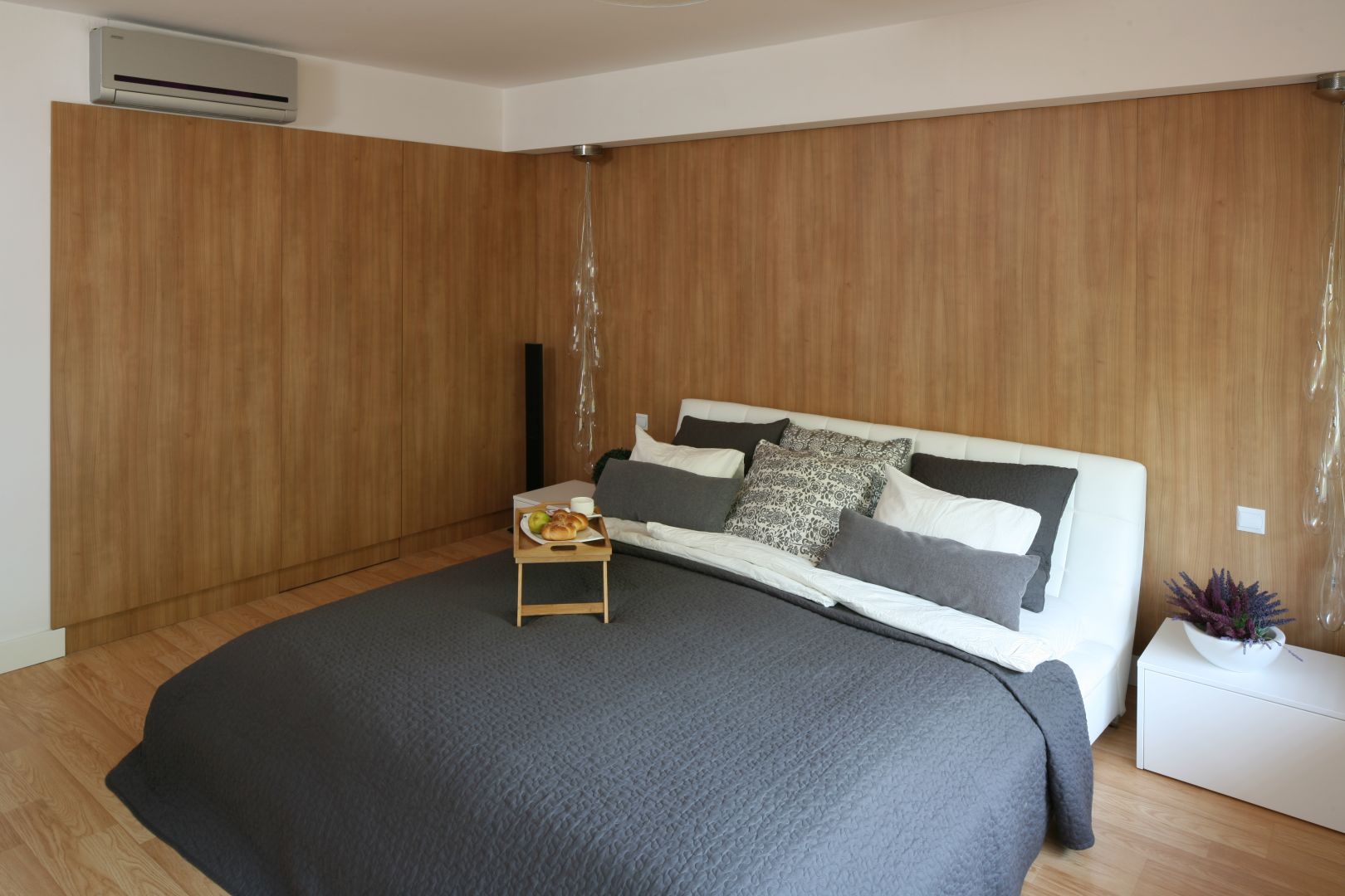 Nowoczesna sypialnia miała być przytulna, co udało się uzyskać dzięki ścianie wykończonej drewnem. Projekt: Małgorzata Błaszczak. Fot. Bartosz Jarosz 